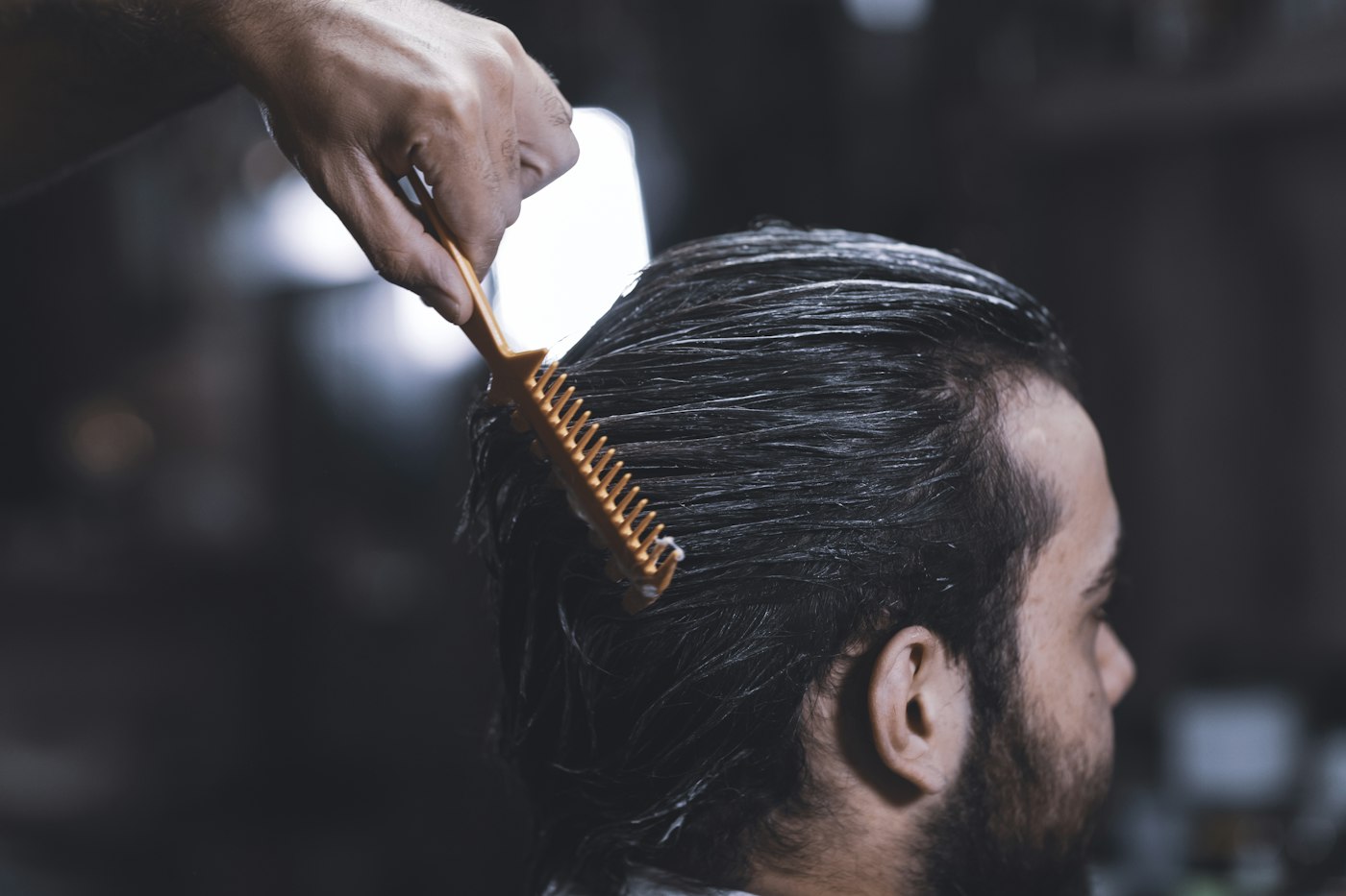 Illustrative example of a man’s side-parted haircut being combed; not a Golden Scissors customer